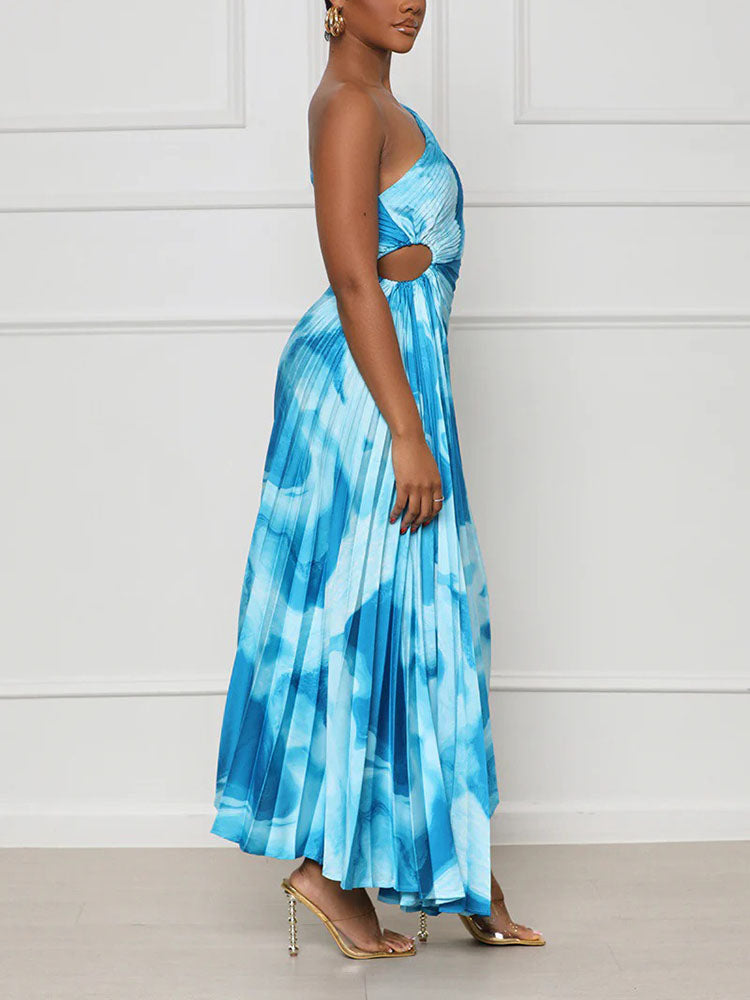 Woman wearing a blue tie-dye one-shoulder pleated maxi dress from the side, showing cut-out detail.