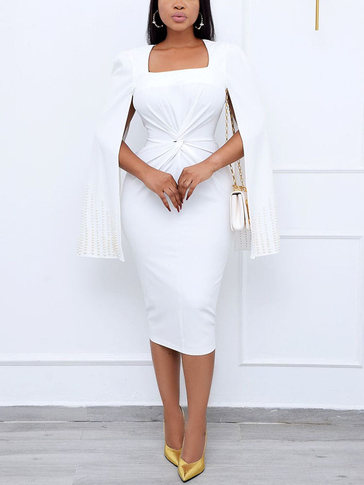Woman wearing a white knee-length dress with cape sleeves and a square neckline.