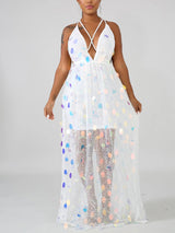 Woman wearing a white sequined maxi dress with a deep V-neck and criss-cross straps.