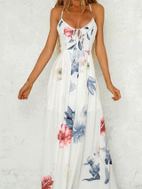 Woman wearing a white floral print maxi dress with spaghetti straps.