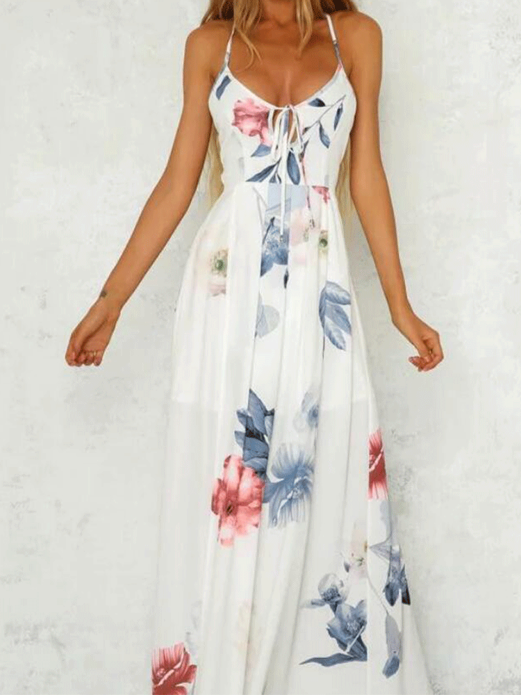 Woman wearing a white floral print maxi dress with spaghetti straps.