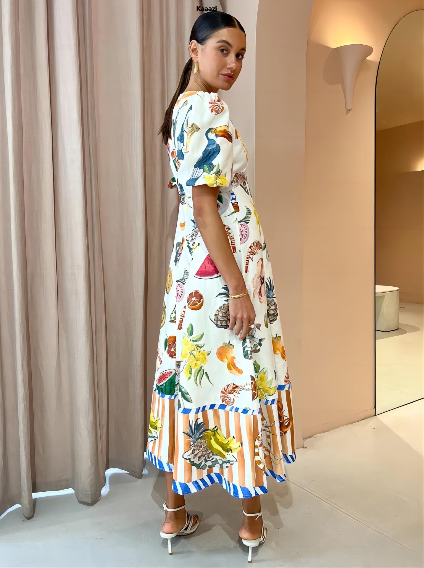 Side view of a woman wearing a white midi dress adorned with a playful tropical print, showcasing the puff sleeves and the striped hemline with seafood illustrations.