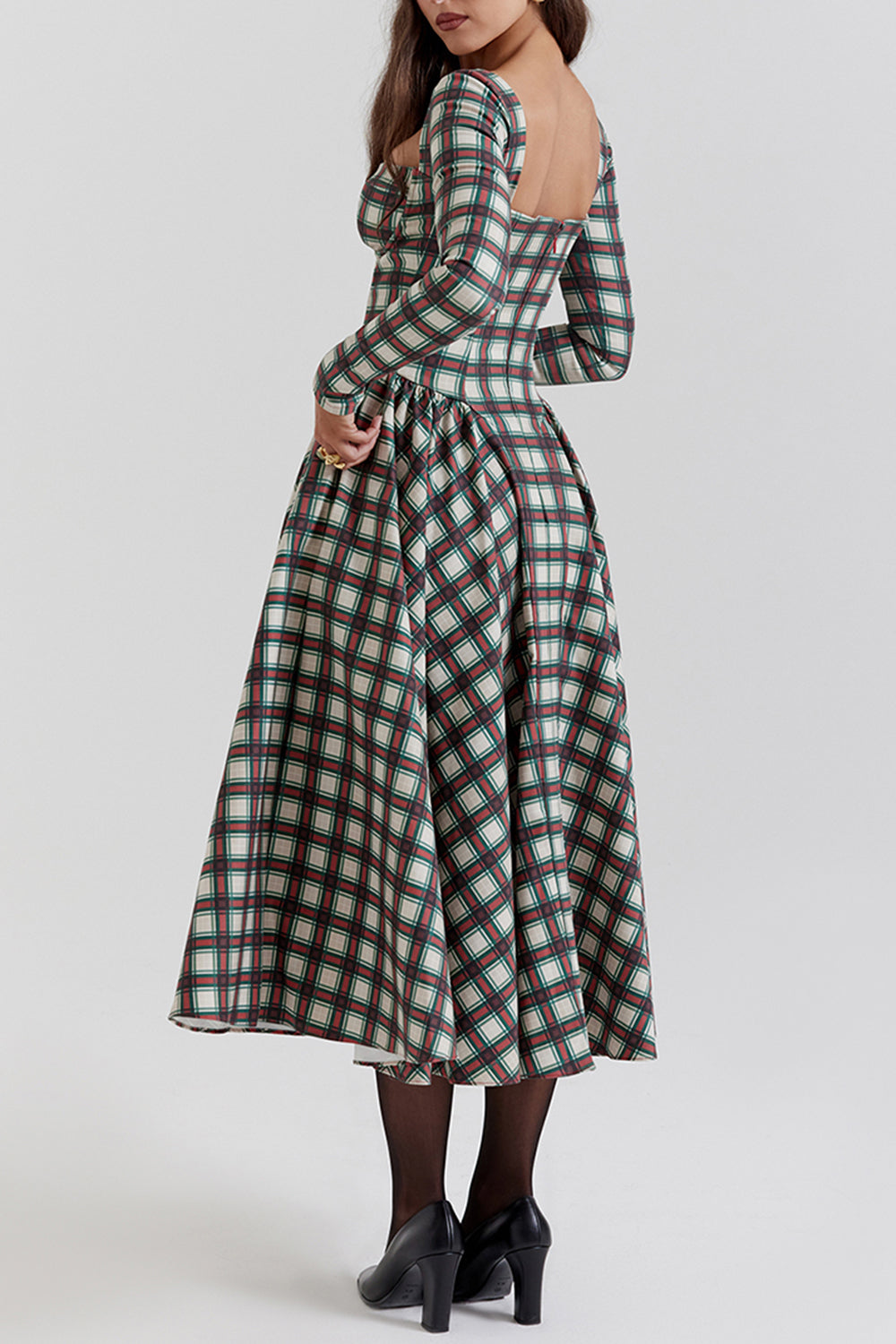 Back view of a woman wearing a long-sleeved plaid midi dress with a full skirt.