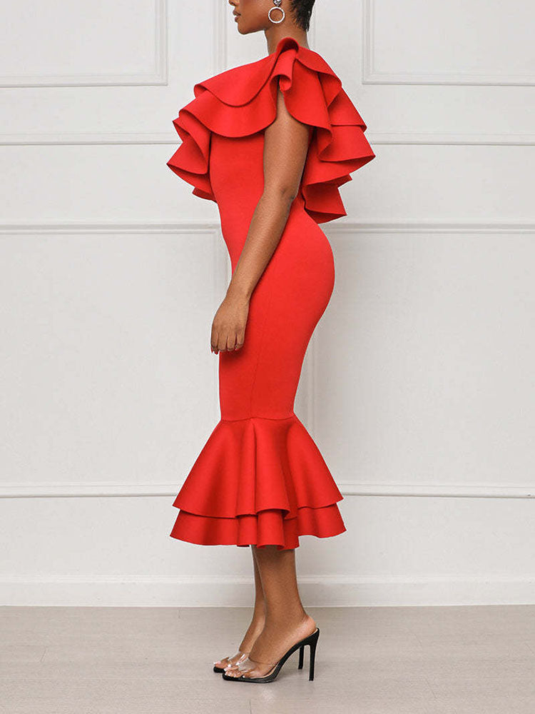 Side view of a woman in a red one-shoulder midi dress with ruffle details and a mermaid hem.