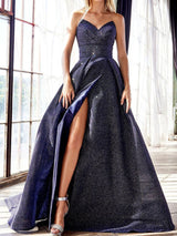 Model wearing a navy blue sparkly strapless ball gown with a high slit, showing the leg.