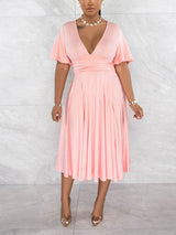 Front view of a woman in a light pink midi dress with a V-neck and flutter sleeves