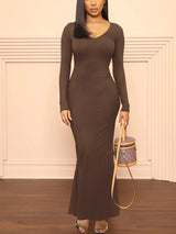 Woman wearing a long-sleeved, ribbed knit maxi dress in brown, front view.