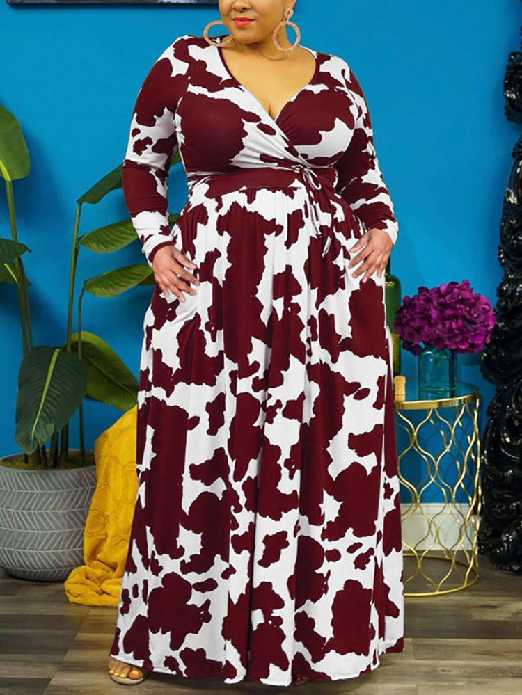 Woman with hands in pockets wearing a burgundy and white cow print maxi dress.