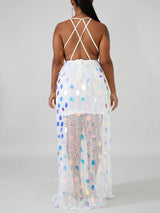 Back view of a woman wearing a white sequined maxi dress with an open back and criss-cross straps.