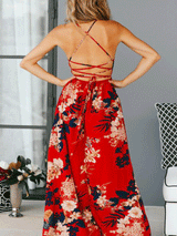 Back view of a woman in a red floral print maxi dress with an open back and criss-cross straps.