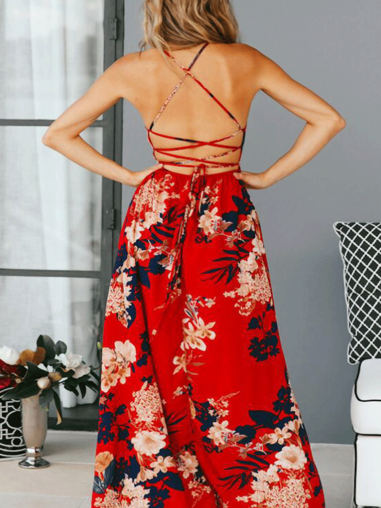 Back view of a woman in a red floral print maxi dress with an open back and criss-cross straps.