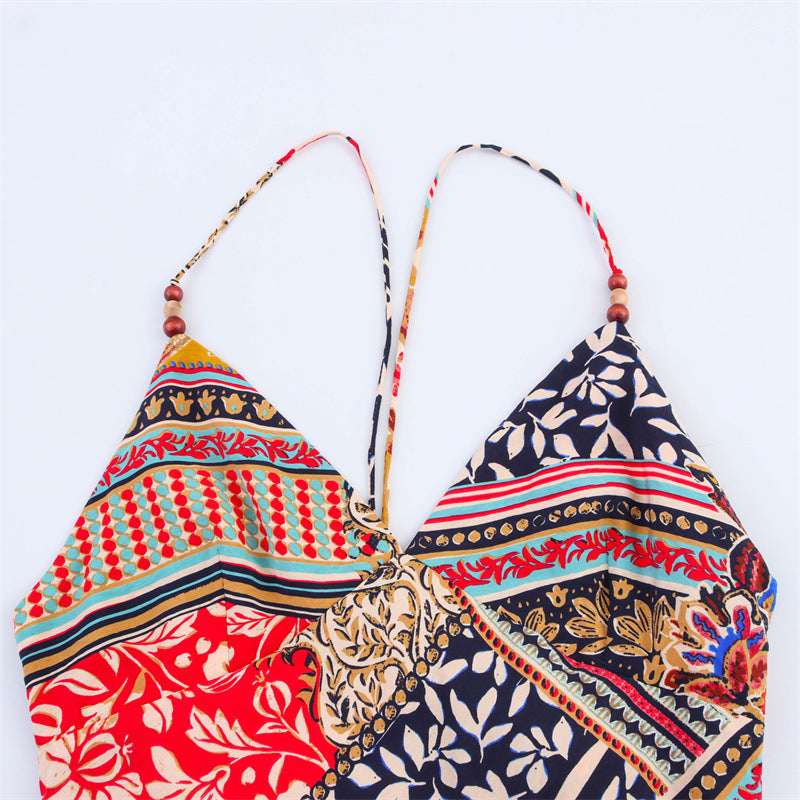 Close-up of the v-neckline and spaghetti straps of a patchwork print maxi dress, showing wooden beads.