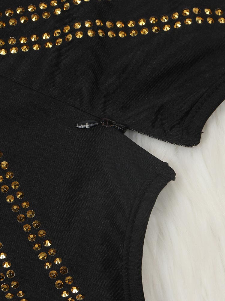 Close-up of the zipper and embellishments on a black long-sleeved dress.