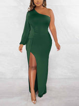 Woman wearing a dark green one-shoulder maxi dress with a high slit and long sleeve.