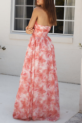 Model showcasing a strapless floral print maxi dress with a ruched bodice and a flowing skirt