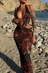 Woman posing in a printed maxi dress on a beach