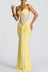 Close-up of a woman's torso in a yellow gown, highlighting the sheer panel and ruched waist.