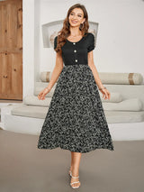 Woman wearing a black short-sleeve top with a floral print midi skirt.