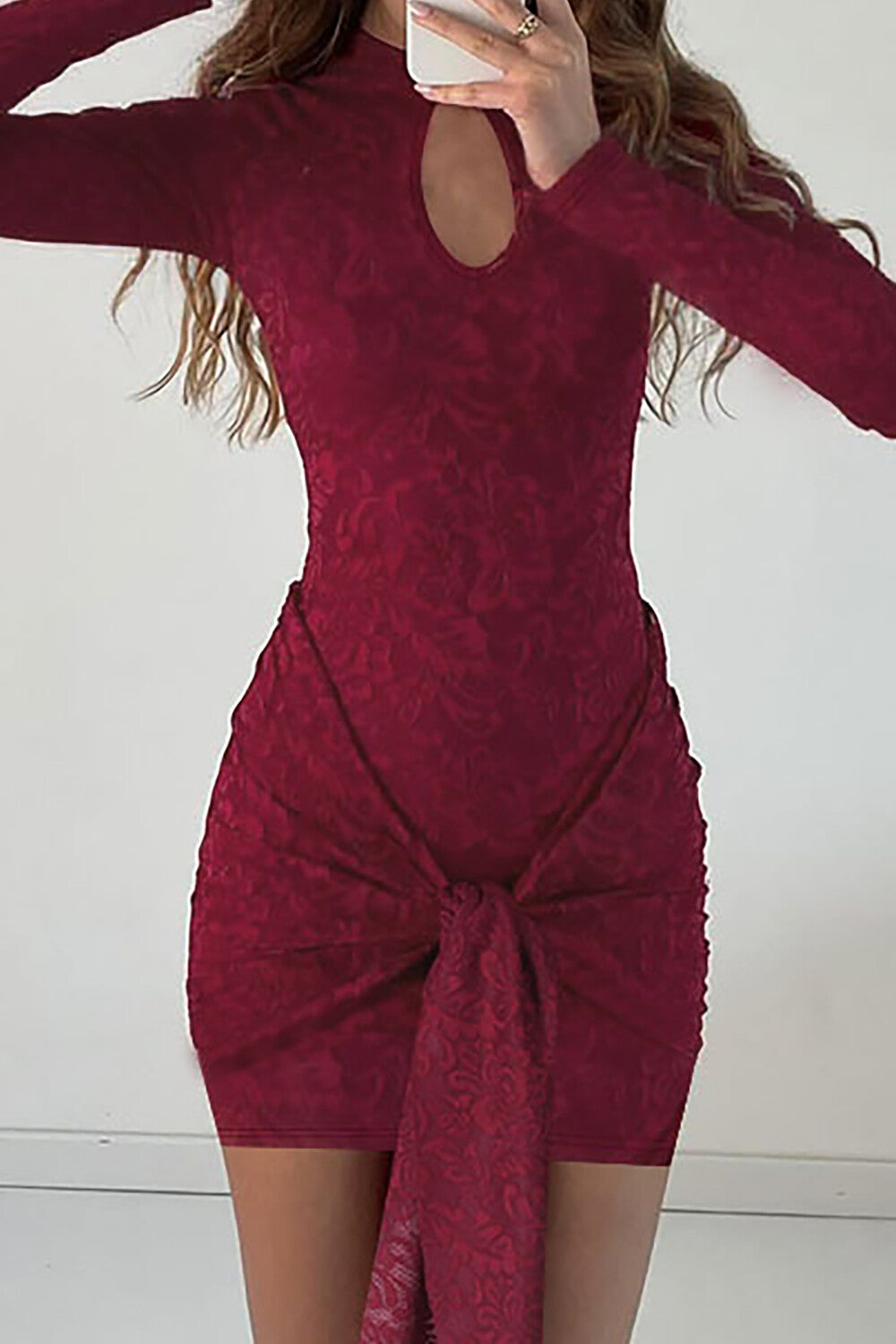 Close-up of a maroon lace mini dress with a keyhole neckline and long sleeves.