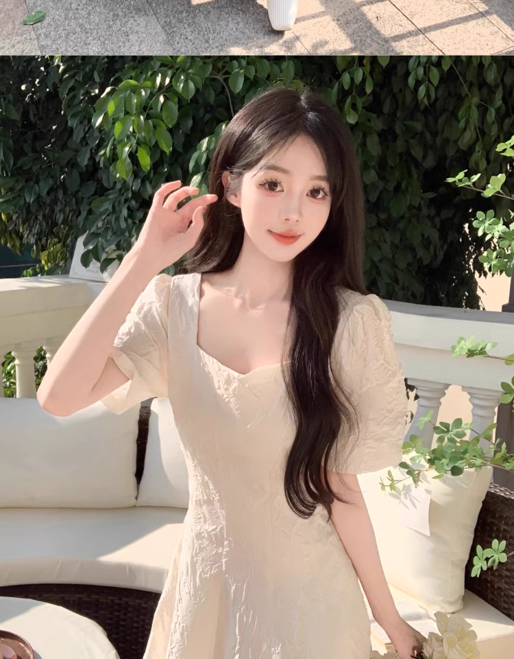 Close-up of a woman wearing a cream-colored textured dress with puff sleeves and a square neckline.