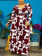 Woman wearing a burgundy and white cow print maxi dress with long sleeves and a surplice neckline.