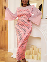 Close-up of the ruffled neckline and bell sleeves of a pink patterned dress.