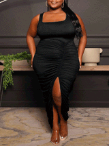 woman wearing a black ruched midi dress with a square neckline and high slit
