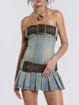 Studio shot of a strapless denim corset dress with brown belt details and a pleated skirt.