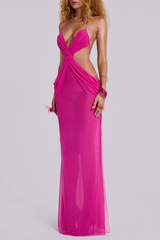 Side view of a woman in a pink sheer mesh maxi dress, showcasing the high slit and back detail.