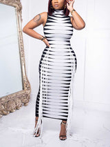 Woman in a black and white striped knit dress with fringe, posing in front of a mirror.