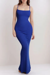 Woman in a long royal blue ribbed knit dress with thin straps.
