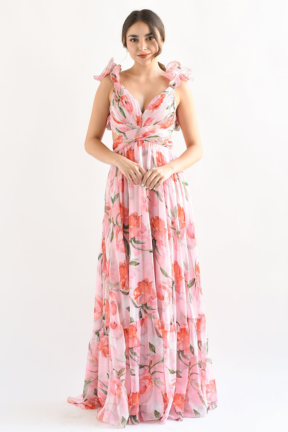 Woman wearing a pink floral print maxi dress with ruffled shoulder straps and a plunging neckline, standing against a white background.