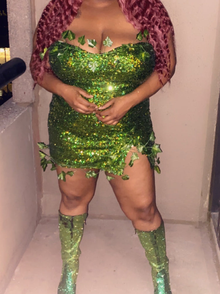 Plus-size woman wearing a green sequined mini dress with leaf appliques, red curly wig, and green sequined boots.