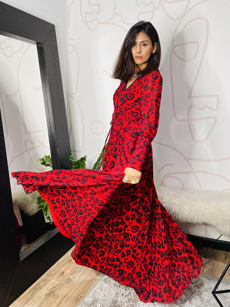 Woman twirling in a red leopard print maxi dress, the skirt flowing dramatically.