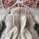 Close-up of the bodice of a cream-colored chiffon dress with spaghetti straps and a V-neck.