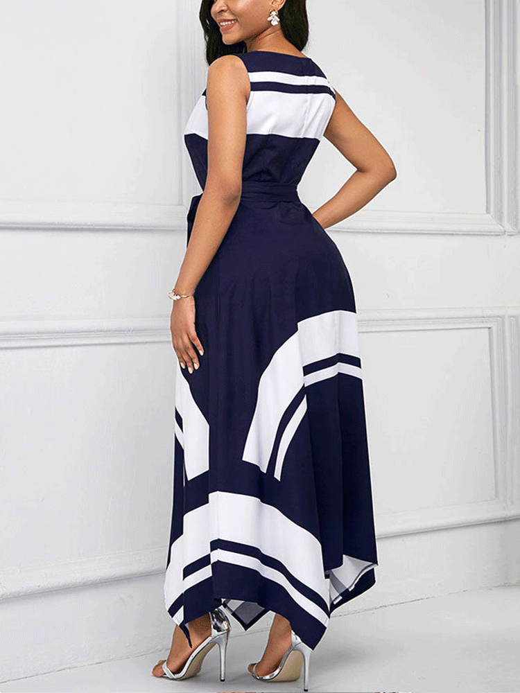 Woman wearing a navy blue and white sleeveless A-line maxi dress with a scoop neck, tie waist, and asymmetrical hemline, back view