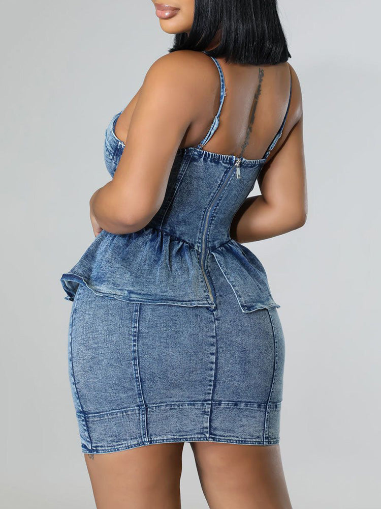 Back view of a woman in a blue denim peplum dress with a zipper closure.
