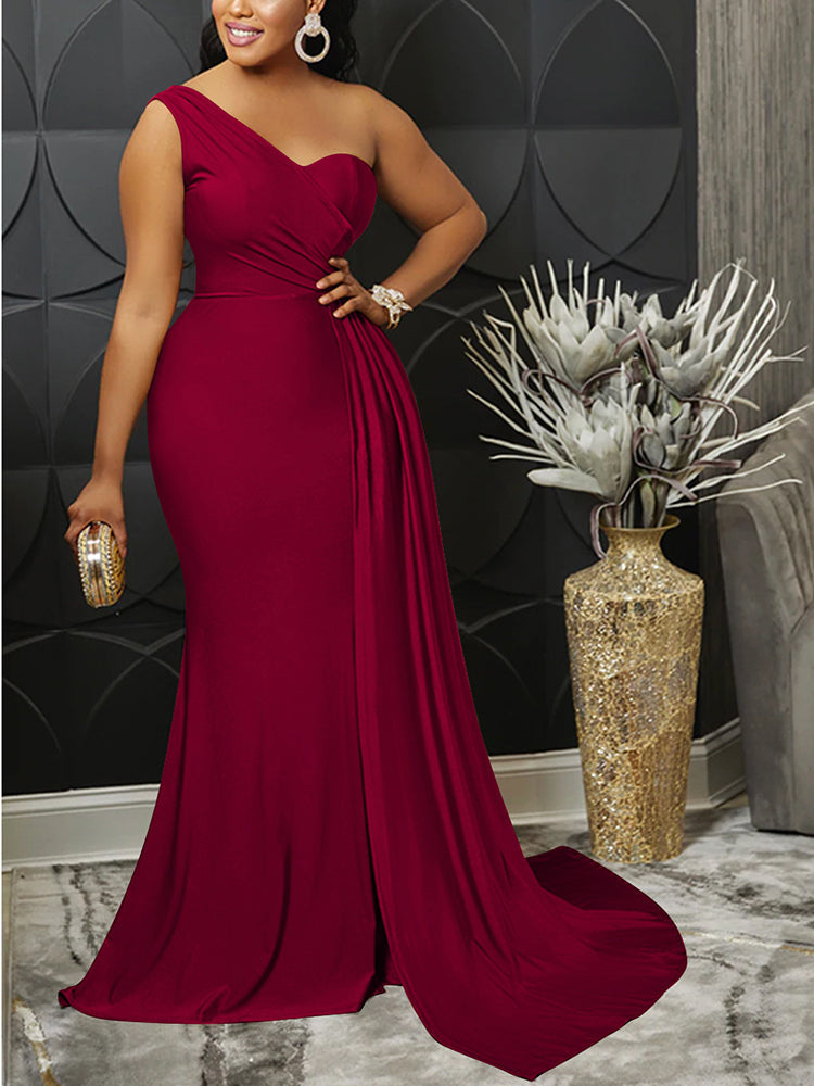 Woman wearing a burgundy one-shoulder formal gown with a thigh-high slit and mermaid hemline, holding a clutch.