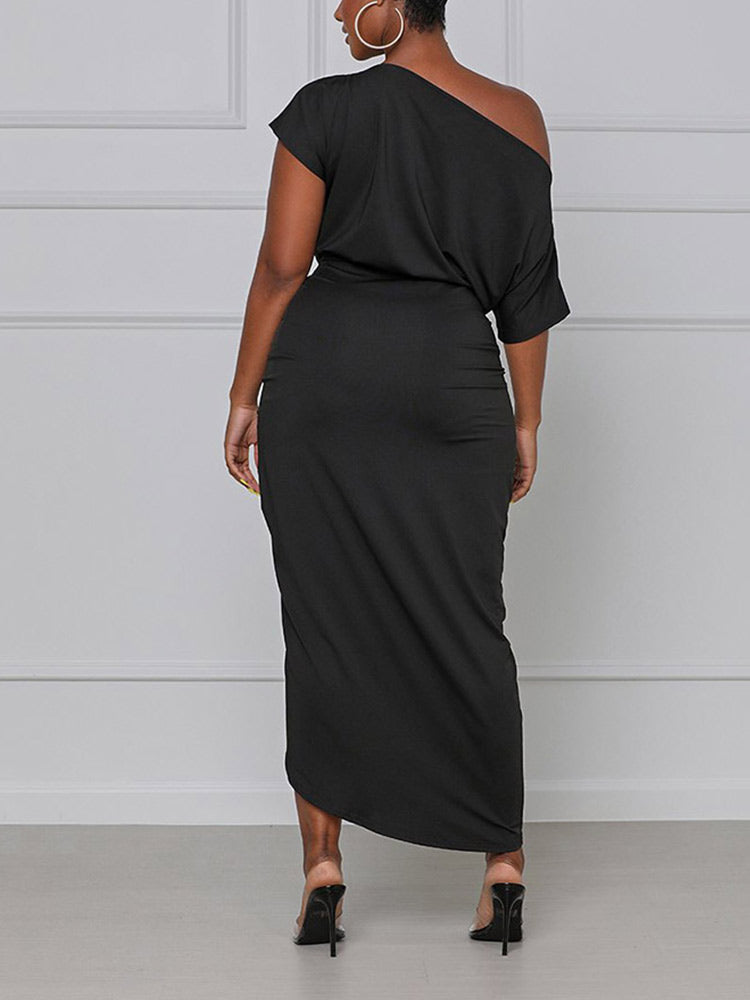 back view of a woman in a black one-shoulder draped dress