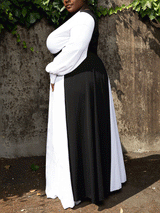 Side view of a woman in a black and white color-block maxi dress, showcasing the A-line silhouette.