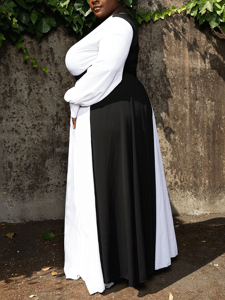 Side view of a woman in a black and white color-block maxi dress, showcasing the A-line silhouette.