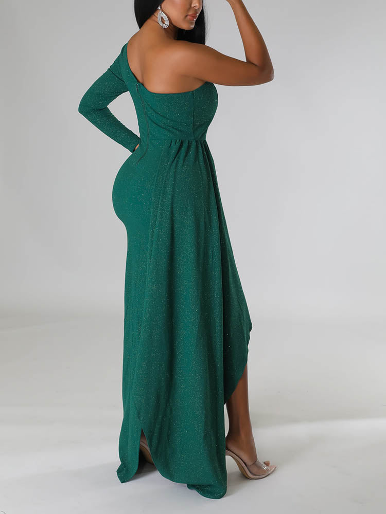 Side view of a woman showcasing the silhouette of a green asymmetrical sparkly dress