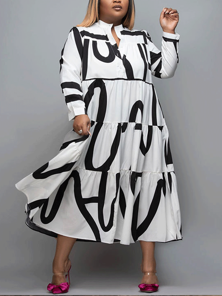 A woman wearing a white midi dress with a bold black graphic print and clear heels with pink bows, posing against a grey background.