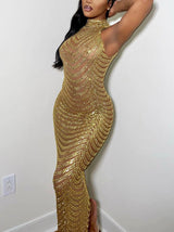 Woman wearing a long, gold beaded, sheer halter neck gown, with her arm raised behind her head.