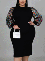 Front view of a woman in a black sheath dress featuring sequin bishop sleeves and a mock neck.