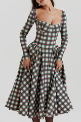 Close-up of a woman wearing a plaid midi dress with a sweetheart neckline and long sleeves.