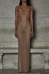 Woman wearing a floor-length strapless shimmering nude gown with ruched detailing.
