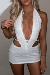 Woman posing in a white lace mini dress with a deep V-neck.