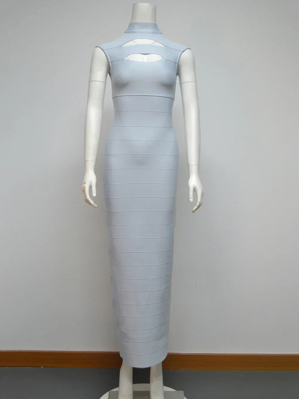 Light blue sleeveless bodycon maxi dress with cut-out detail at the bust and high neckline displayed on a mannequin against a white background.