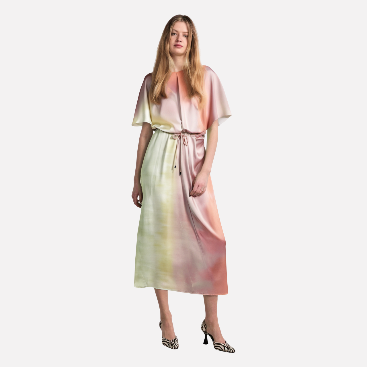 woman wearing a pink, yellow, and green ombre satin midi dress with batwing sleeves and a tie waist
